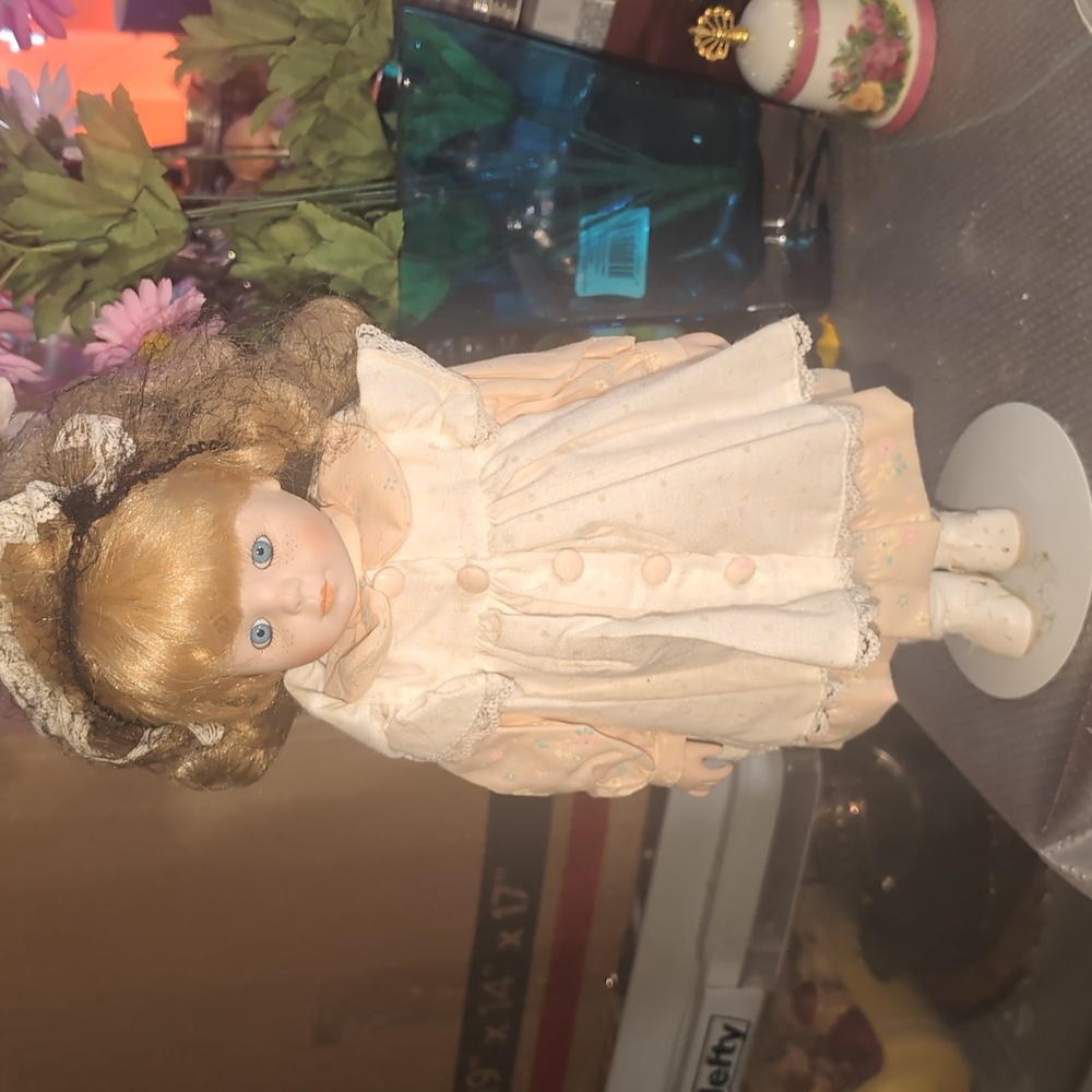 AVAILABLE - Blond haired blue eyed girl in peach porcelain doll 14" Tall w/Stand